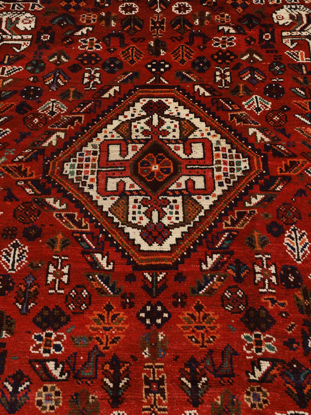 Hand-knotted Shiraz rug with geometric patterns in deep red and blue tones from the Middle East