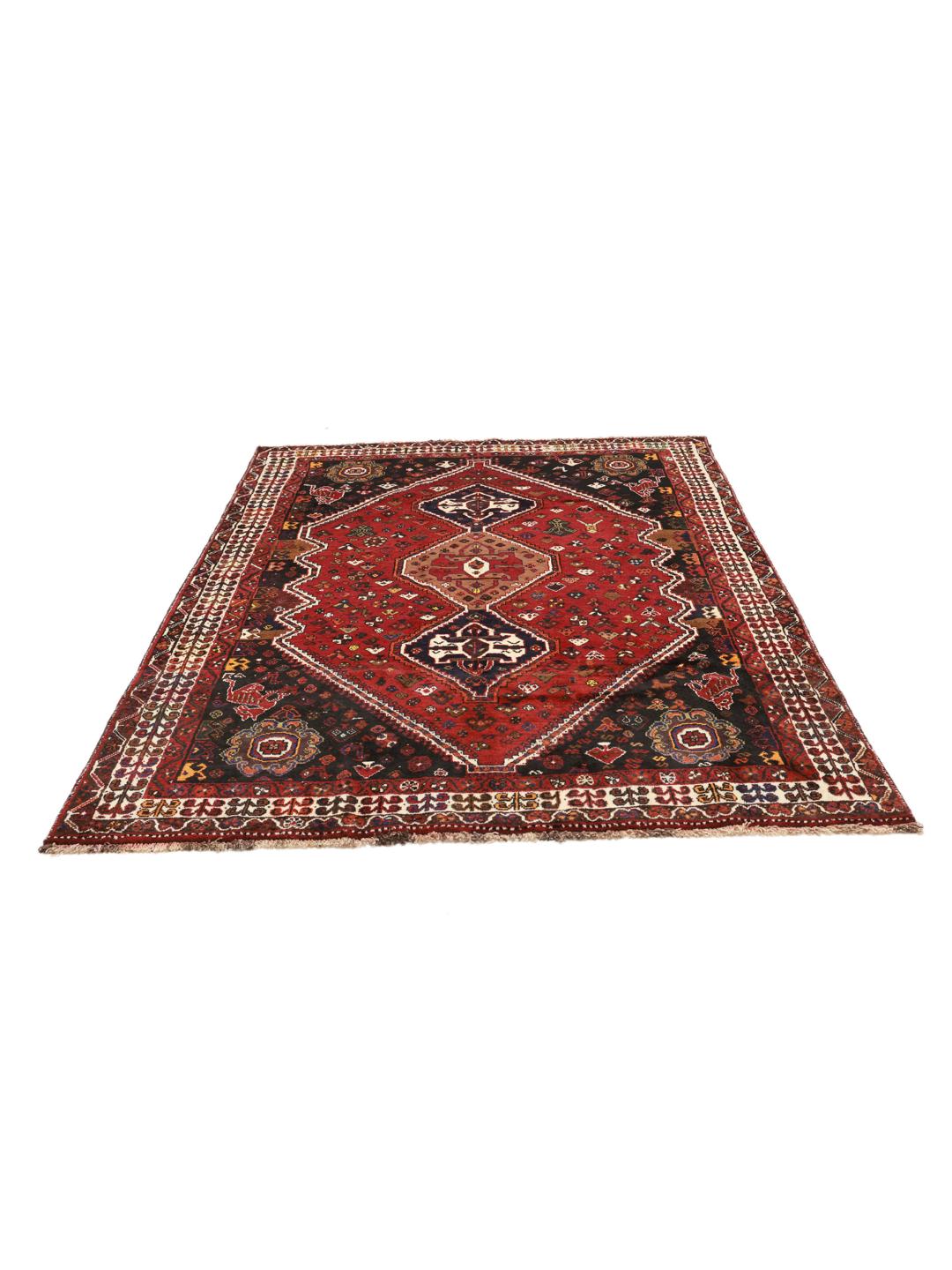 A hand-knotted Shiraz rug from the Middle East featuring a vibrant red and black geometric design.