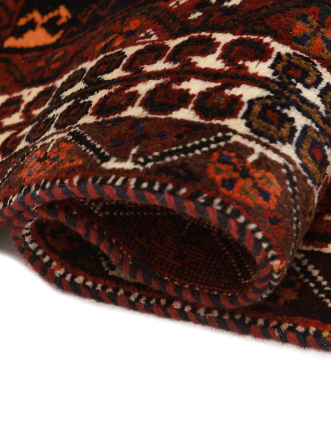 A hand-knotted Shiraz rug from the Middle East featuring a vibrant red and black geometric design.