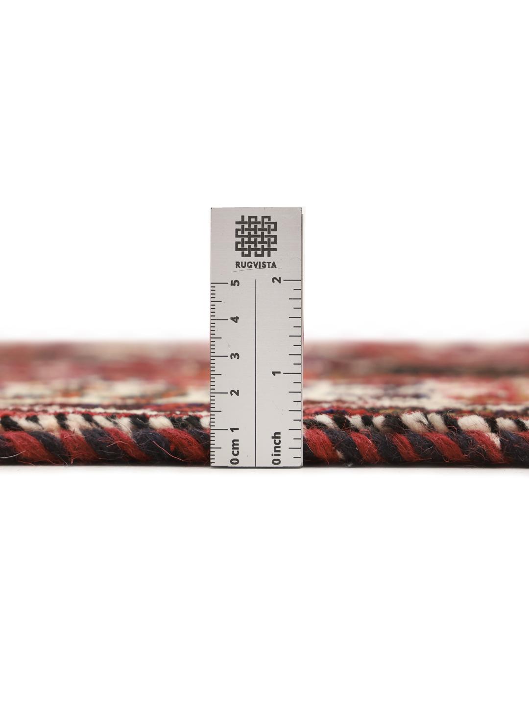 A hand-knotted Shiraz rug from the Middle East featuring a vibrant red and black geometric design.
