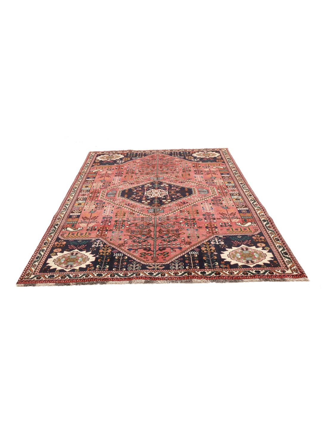 A hand-knotted Middle Eastern rug with a red field and traditional geometric patterns