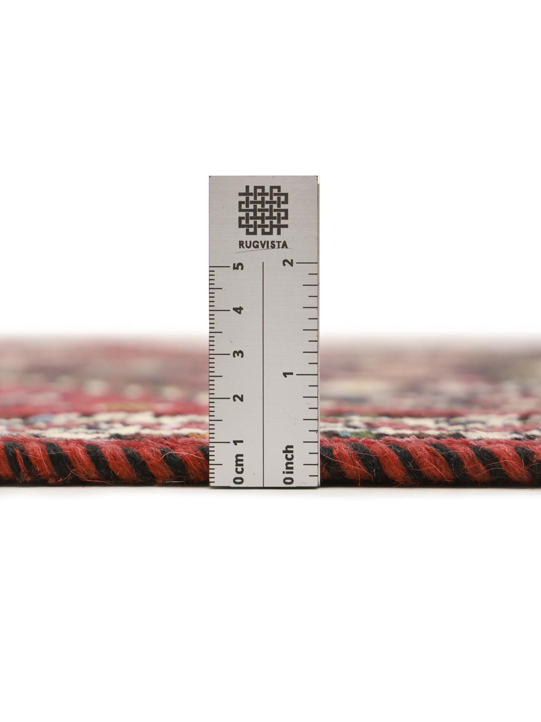 Hand-knotted Shiraz runner with a dark field and geometric motifs in red, blue, and white.