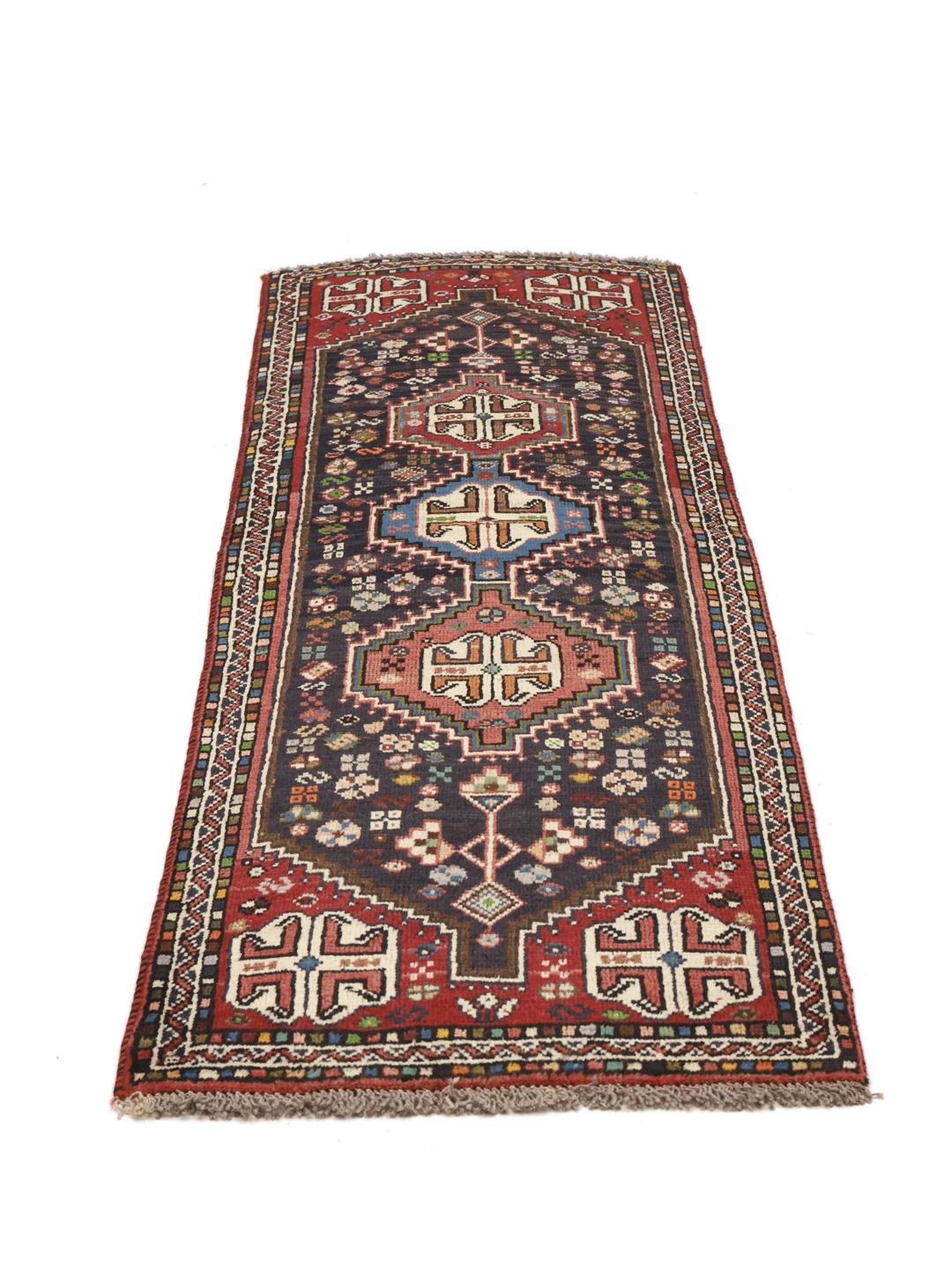 Hand-knotted Shiraz runner with a dark field and geometric motifs in red, blue, and white.