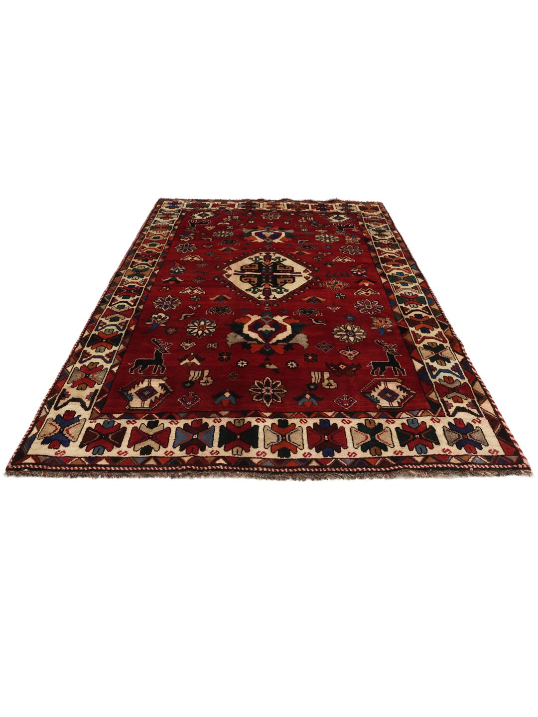 A hand-knotted Ghashghai rug from the Middle East featuring a vibrant red field with intricate geometric motifs.