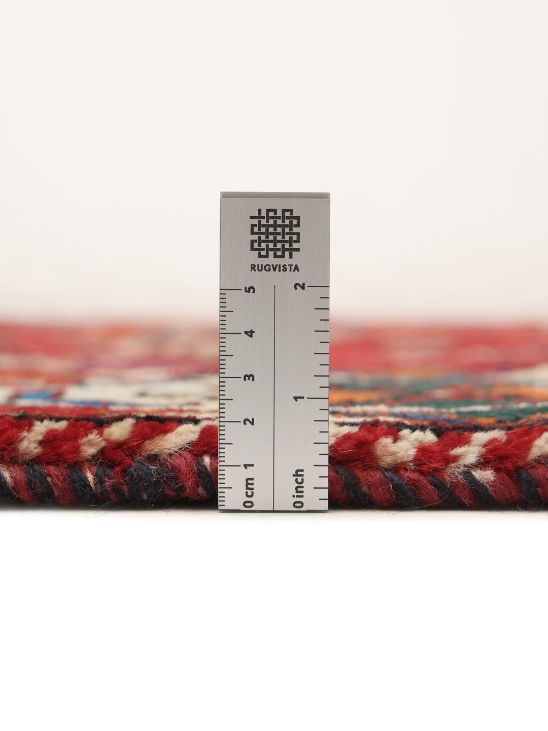 A hand-knotted Ghashghai rug from the Middle East featuring a vibrant red field with intricate geometric motifs.