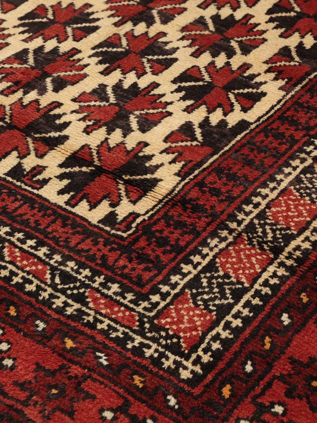 Authentic hand-knotted Baluch rug in red, featuring traditional geometric patterns