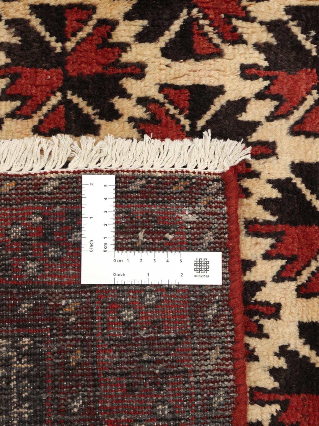 Authentic hand-knotted Baluch rug in red, featuring traditional geometric patterns