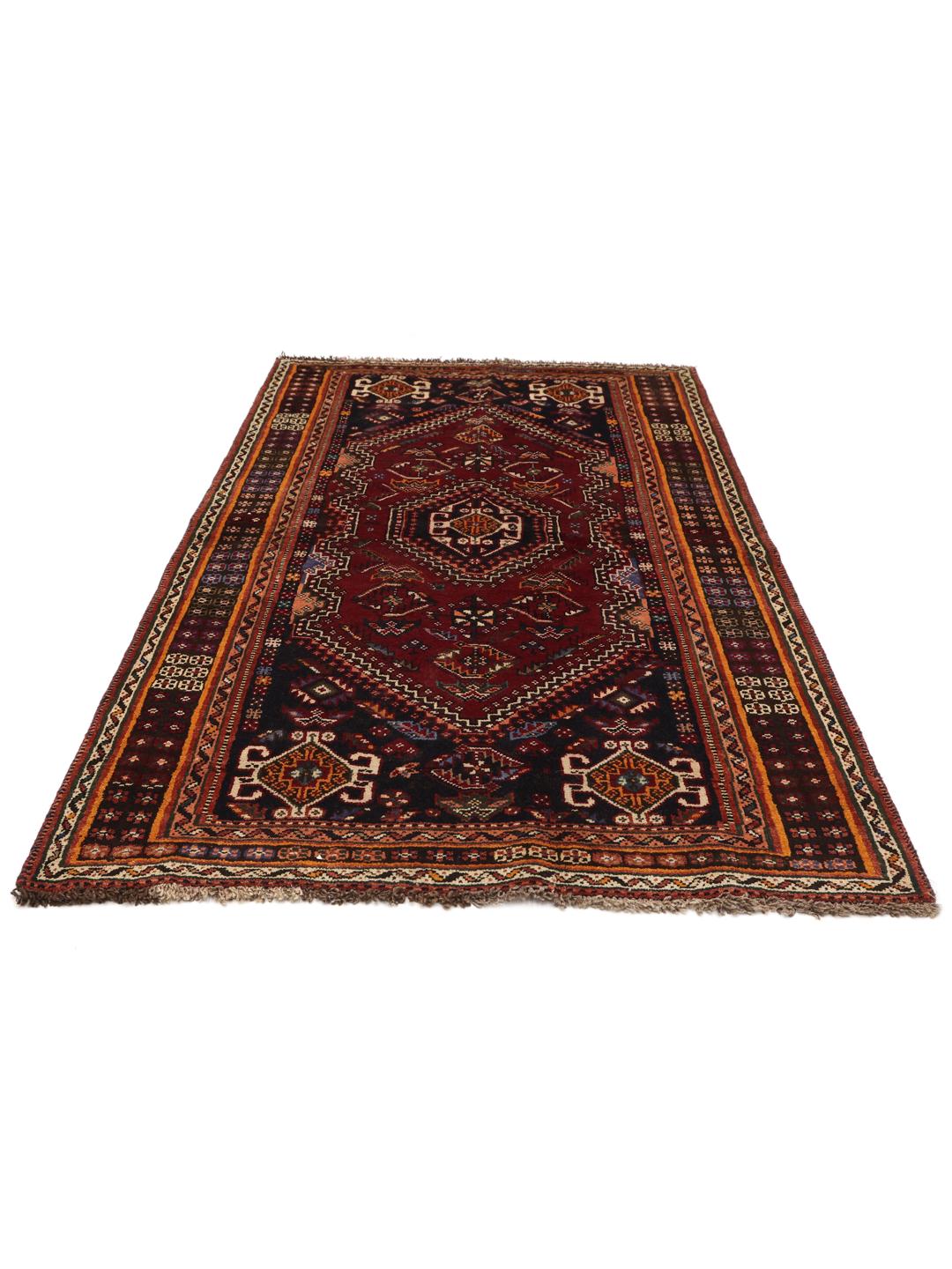 A hand-knotted Shiraz rug from the Middle East featuring a dark-red field and geometric patterns