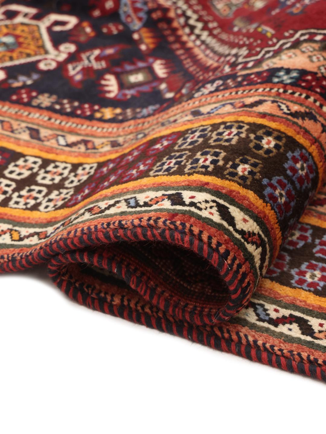 A hand-knotted Shiraz rug from the Middle East featuring a dark-red field and geometric patterns