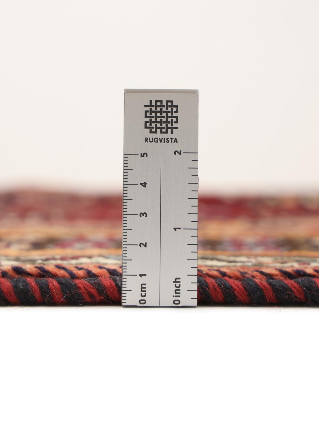 A hand-knotted Shiraz rug from the Middle East featuring a dark-red field and geometric patterns