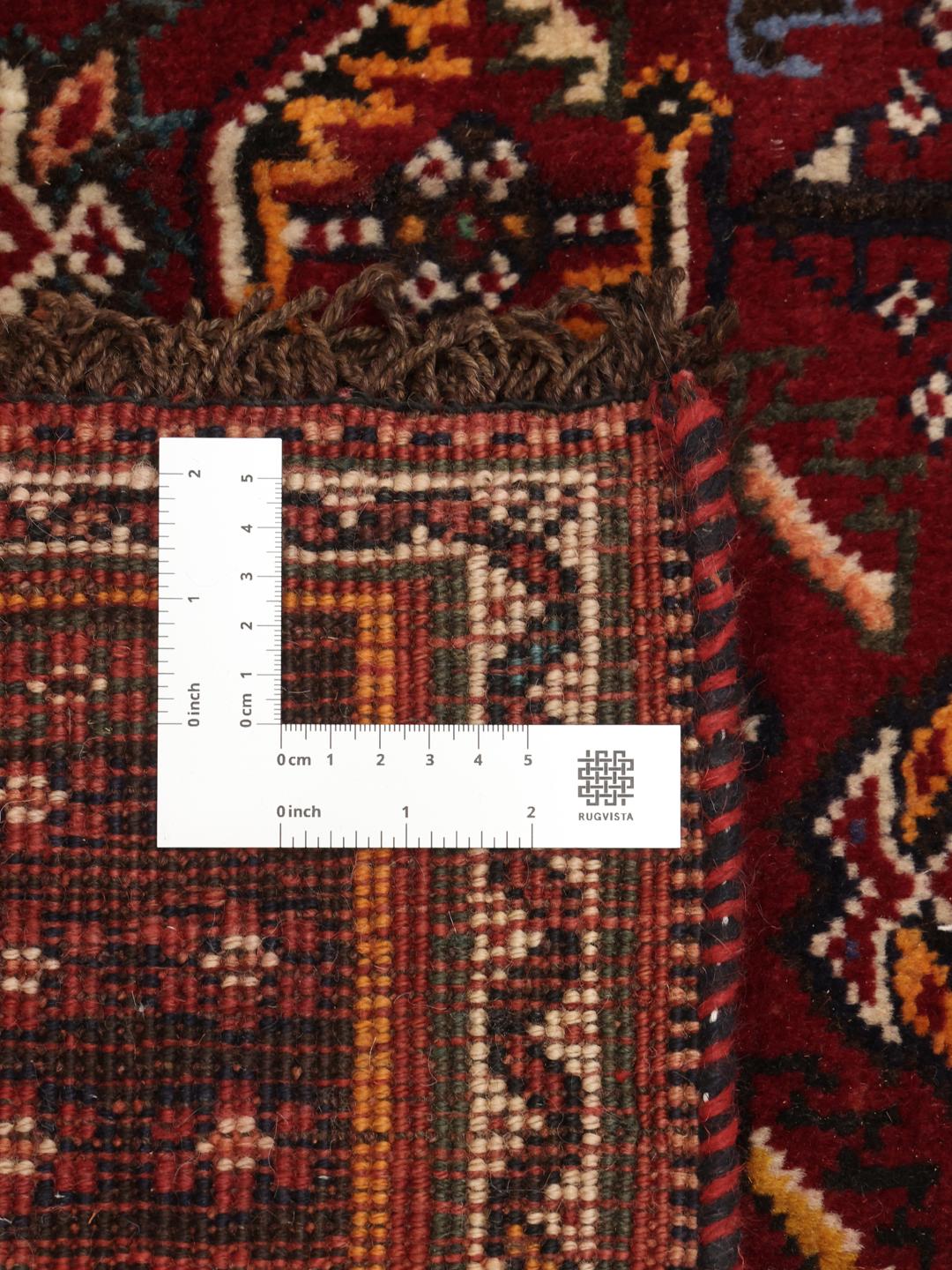 A hand-knotted Shiraz rug from the Middle East featuring a dark-red field and geometric patterns