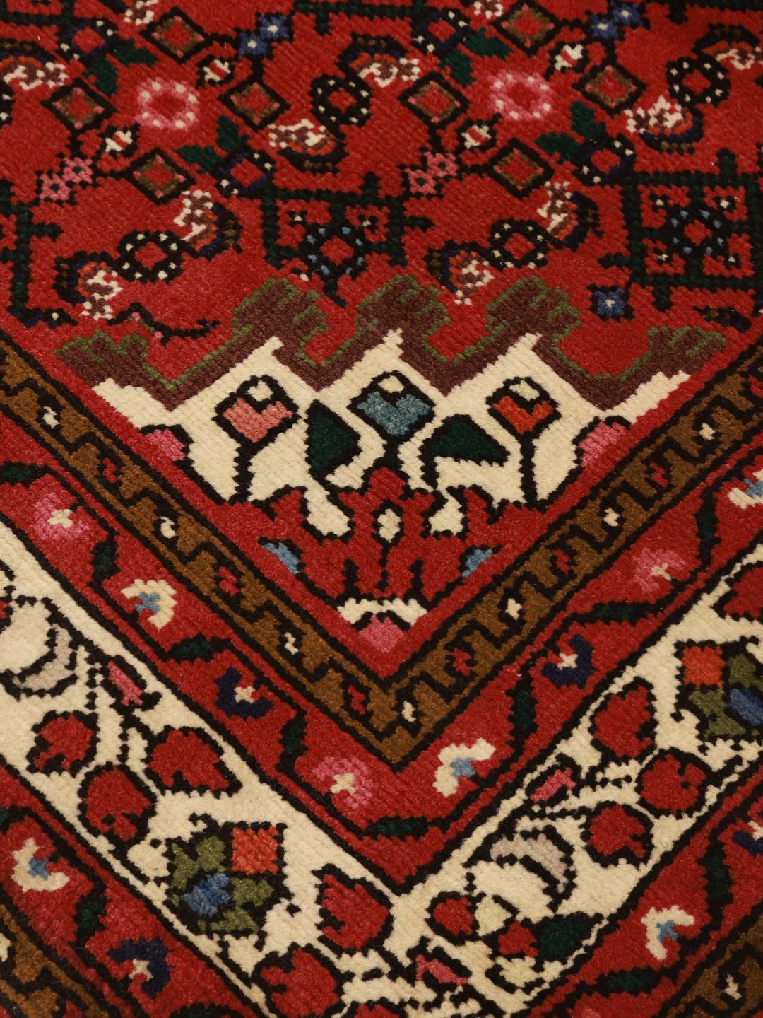 Hand-knotted Hosseinabad rug with a rich red field and traditional Middle Eastern motifs.