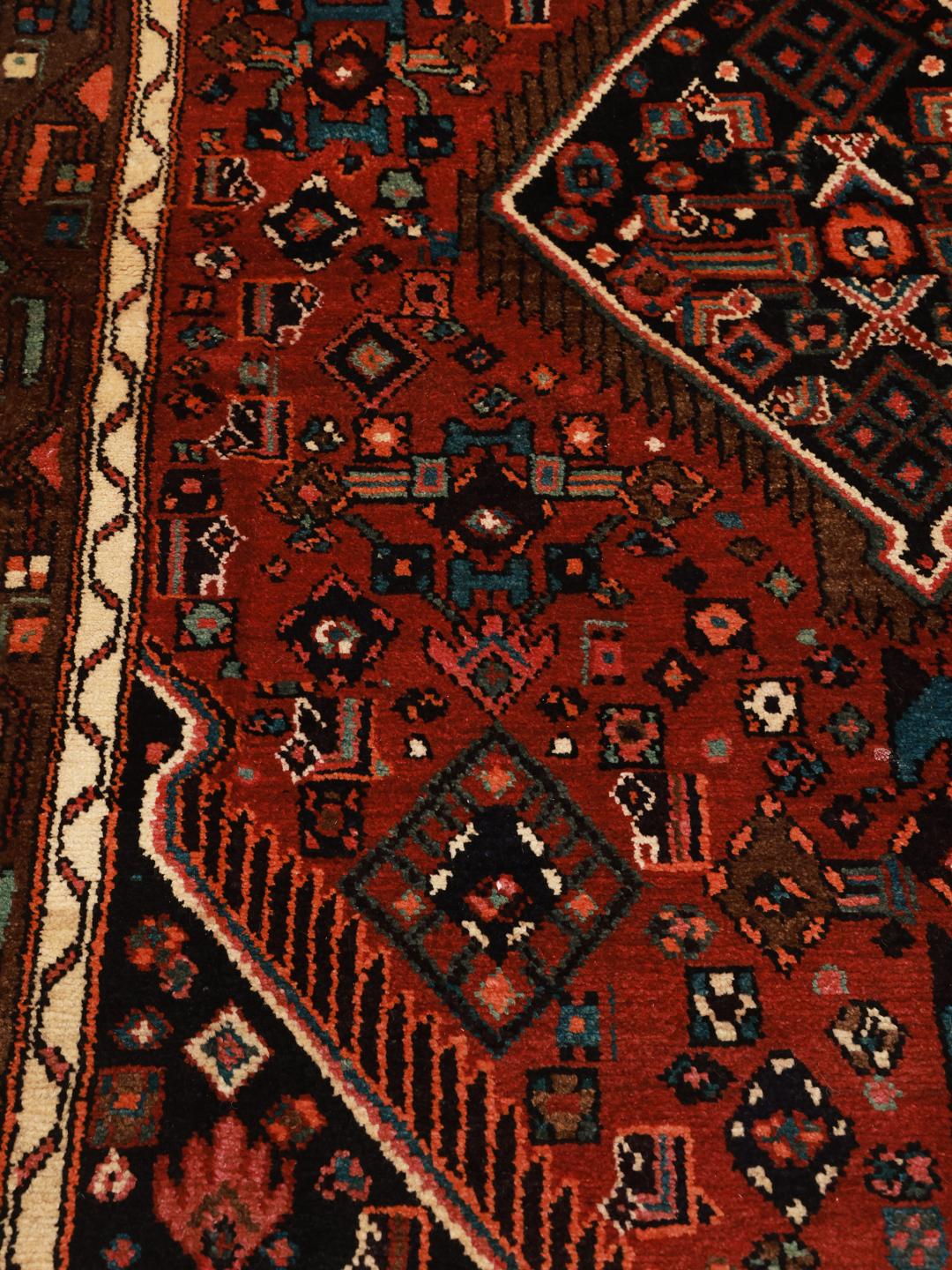 A hand-knotted Hamadan rug from the Middle East featuring a dark-red field with geometric motifs.