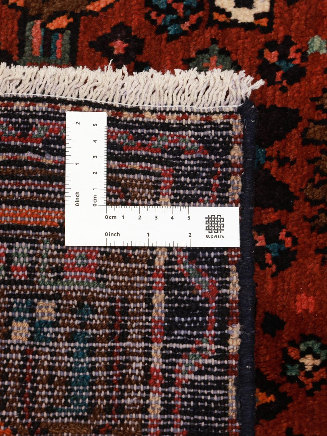 A hand-knotted Hamadan rug from the Middle East featuring a dark-red field with geometric motifs.