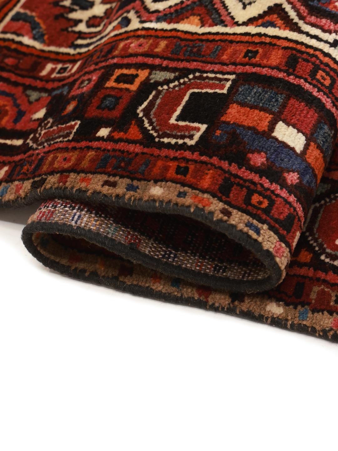 Hand-knotted Hosseinabad rug with geometric patterns in red and dark blue.