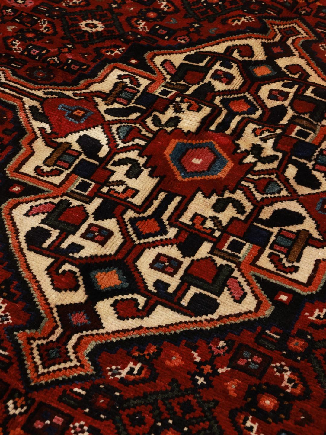 Hand-knotted Hosseinabad rug from the Middle East in dark-red with geometric motifs