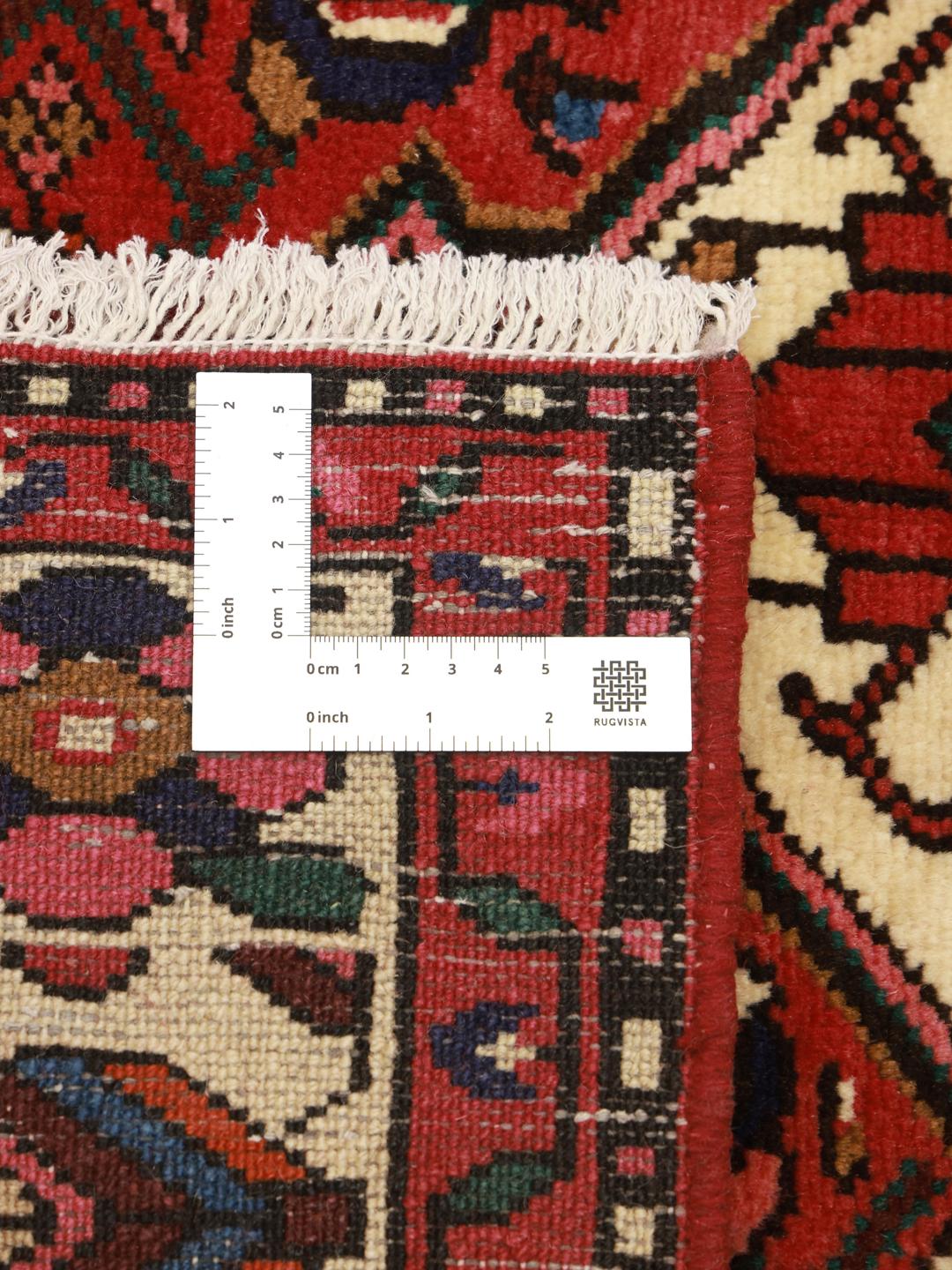 Hand-knotted Hosseinabad rug from the Middle East featuring a red field and a classic medallion pattern.