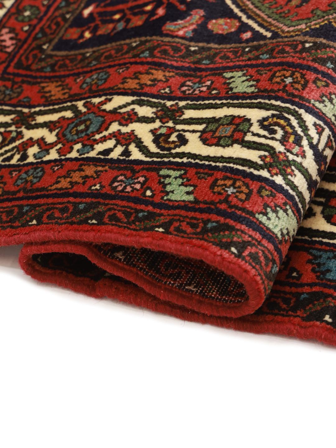 A hand-knotted red Hosseinabad rug from the Middle East.