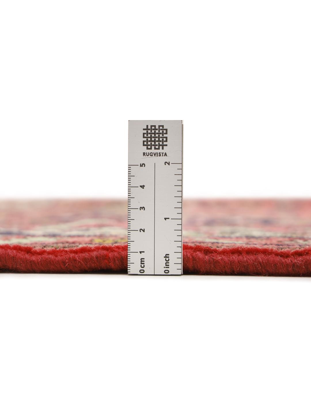 A hand-knotted red Hosseinabad rug from the Middle East.