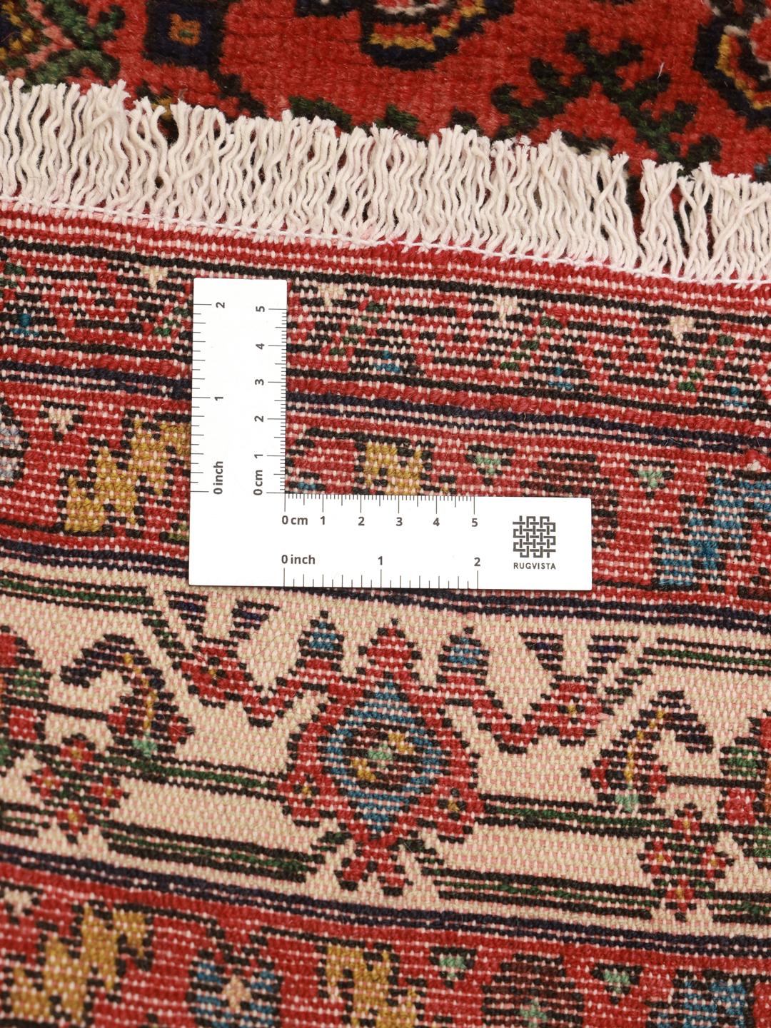 A hand-knotted red Hosseinabad rug from the Middle East.