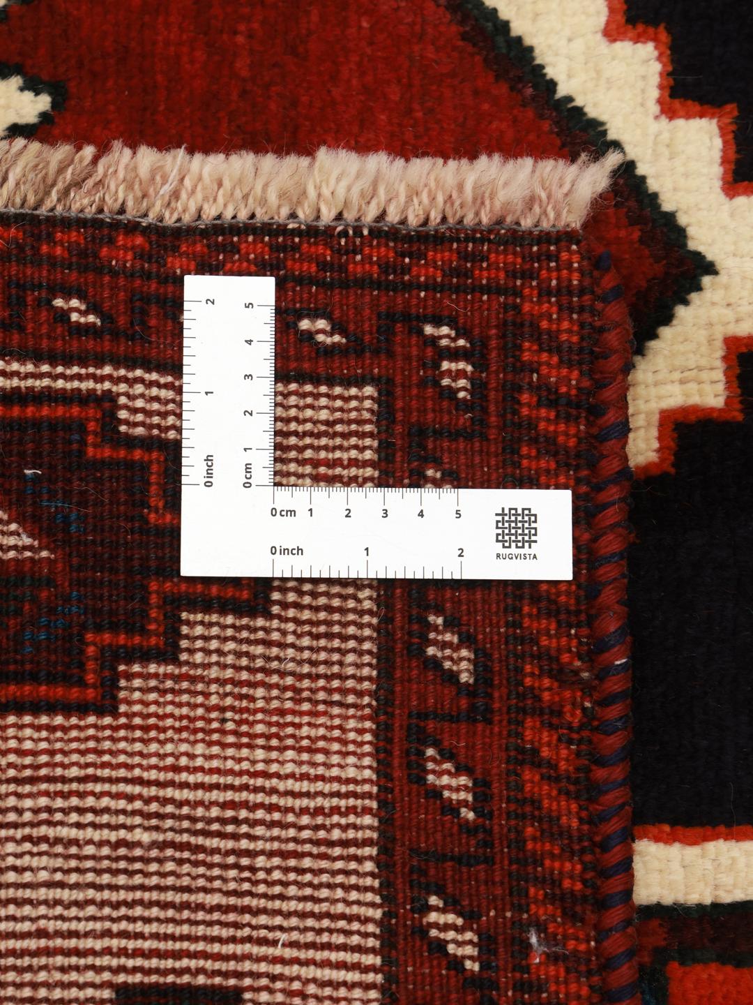 A hand-knotted Lori rug from the Middle East featuring a vibrant red and black geometric medallion design.