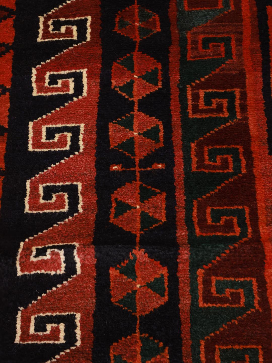 A hand-knotted Lori rug from the Middle East featuring geometric patterns in dark red and black.