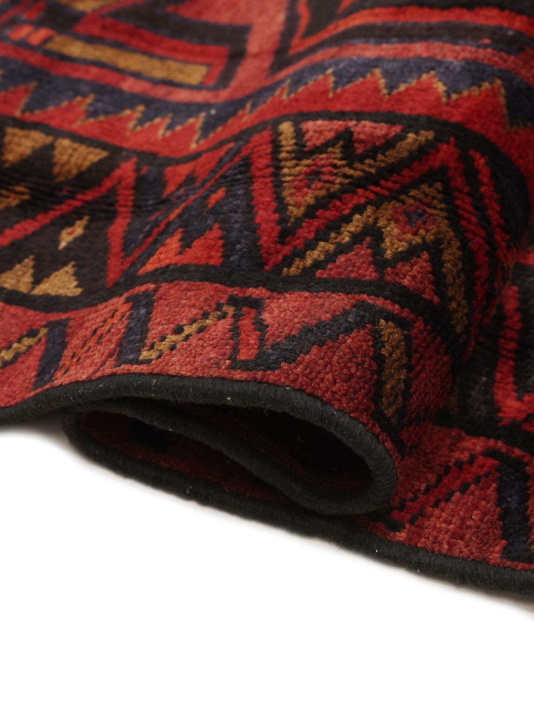 A hand-knotted Lori rug from the Middle East in dark-red and black tones with geometric patterns.