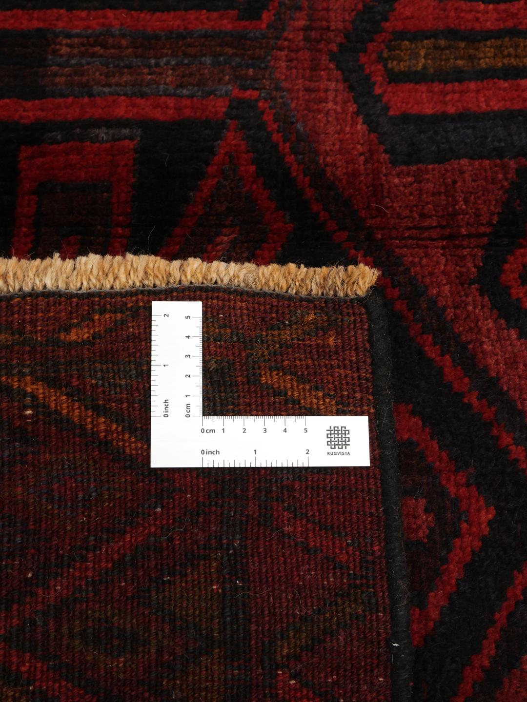 A hand-knotted Lori rug from the Middle East in dark-red and black tones with geometric patterns.
