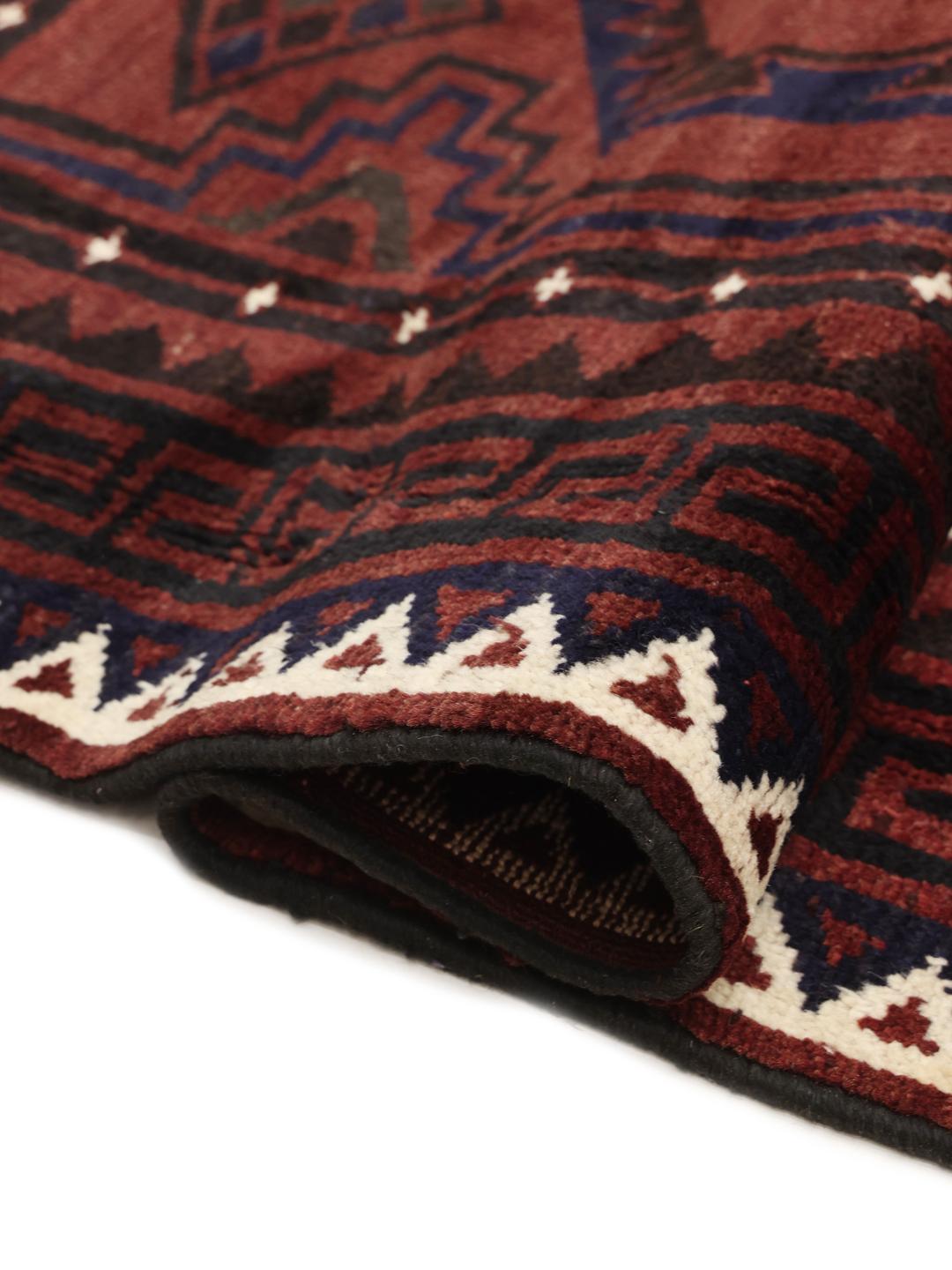 A hand-knotted Lori rug from the Middle East in dark-red with geometric patterns