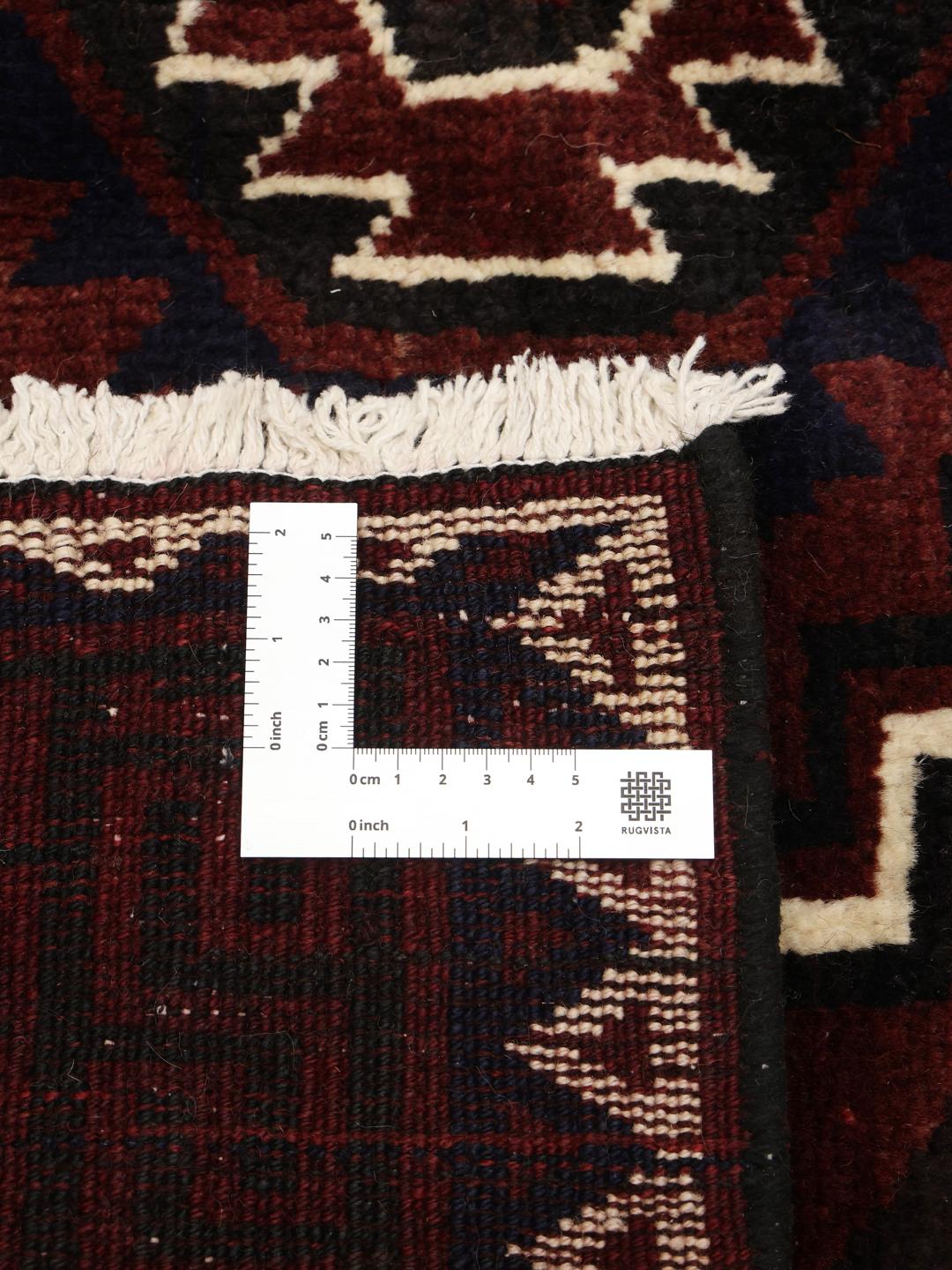 A hand-knotted Lori rug from the Middle East in dark-red with geometric patterns