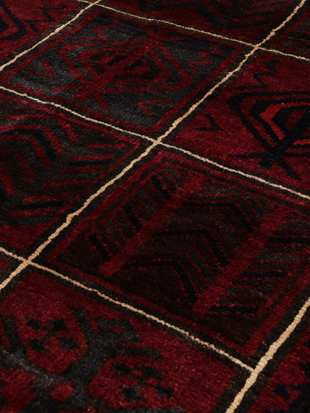 Hand-knotted Lori rug from the Middle East in dark-red and black with geometric patterns
