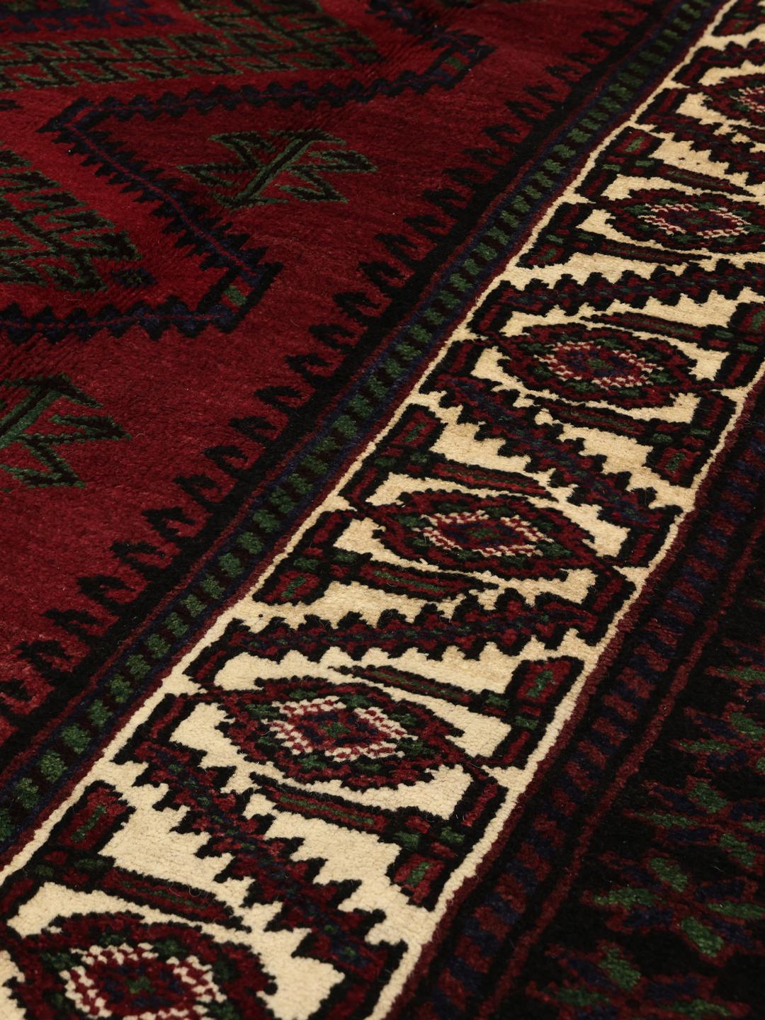 Handmade Lori rug from the Middle East with a deep red field and geometric motifs