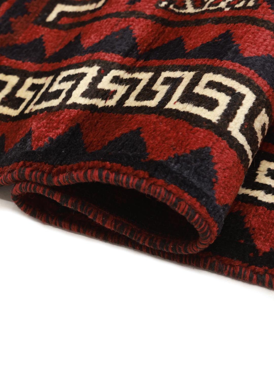 A hand-knotted Lori rug from the Middle East with a deep red and geometric pattern.