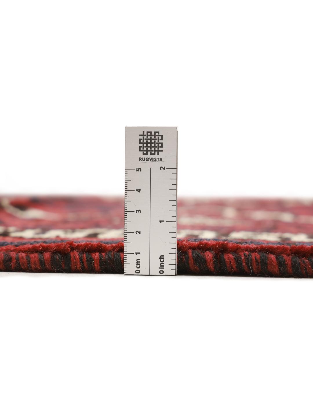 A hand-knotted Lori rug from the Middle East with a deep red and geometric pattern.
