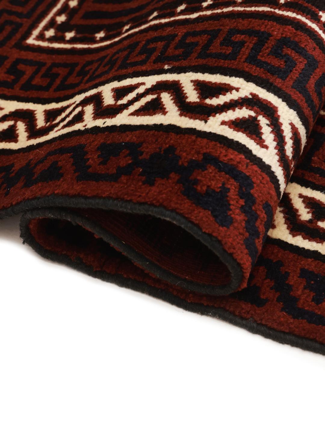 A hand-knotted Lori rug from the Middle East in dark-red with geometric patterns.