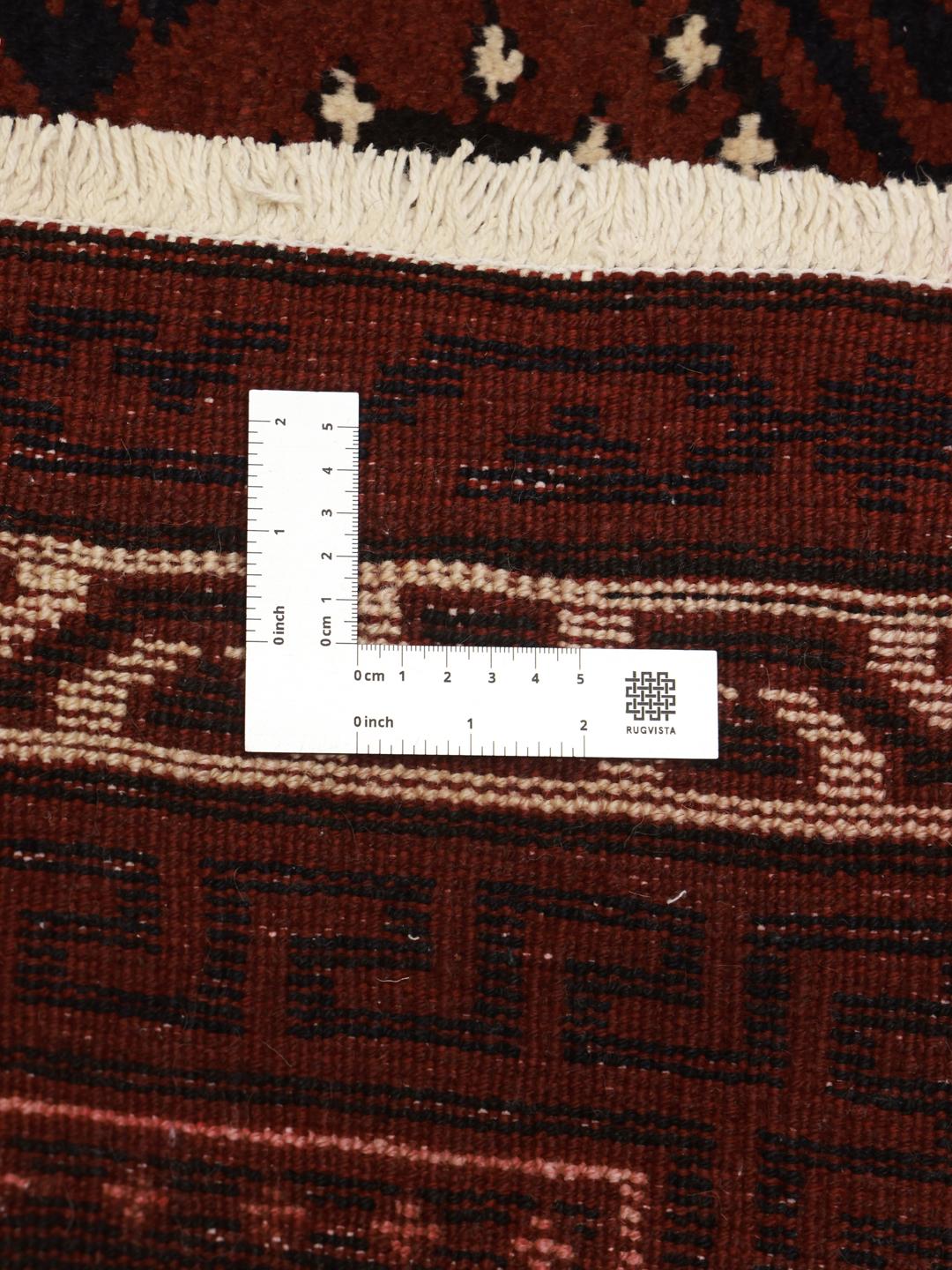 A hand-knotted Lori rug from the Middle East in dark-red with geometric patterns.