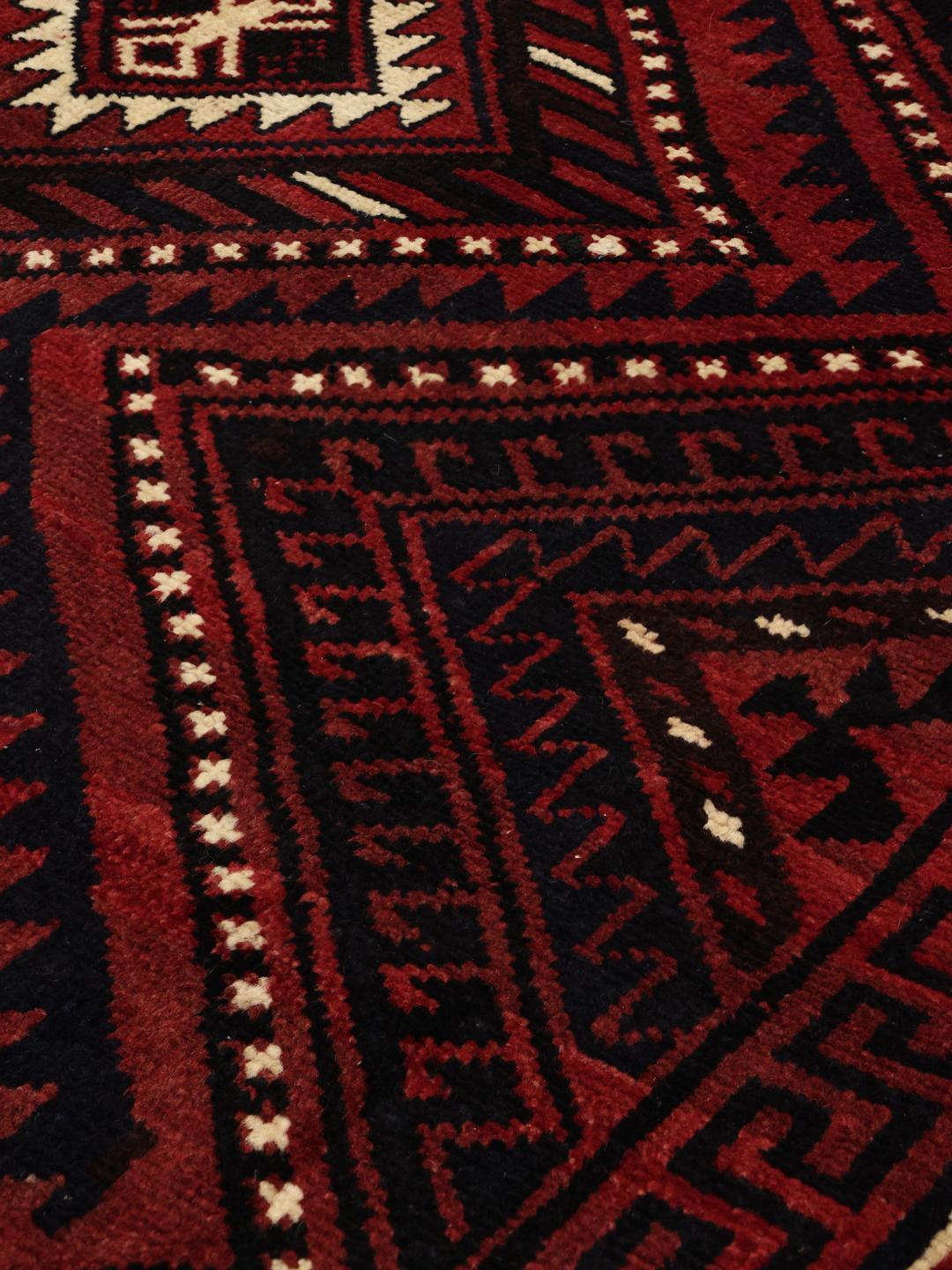 Hand-knotted Lori rug from the Middle East with a deep red and geometric tribal pattern