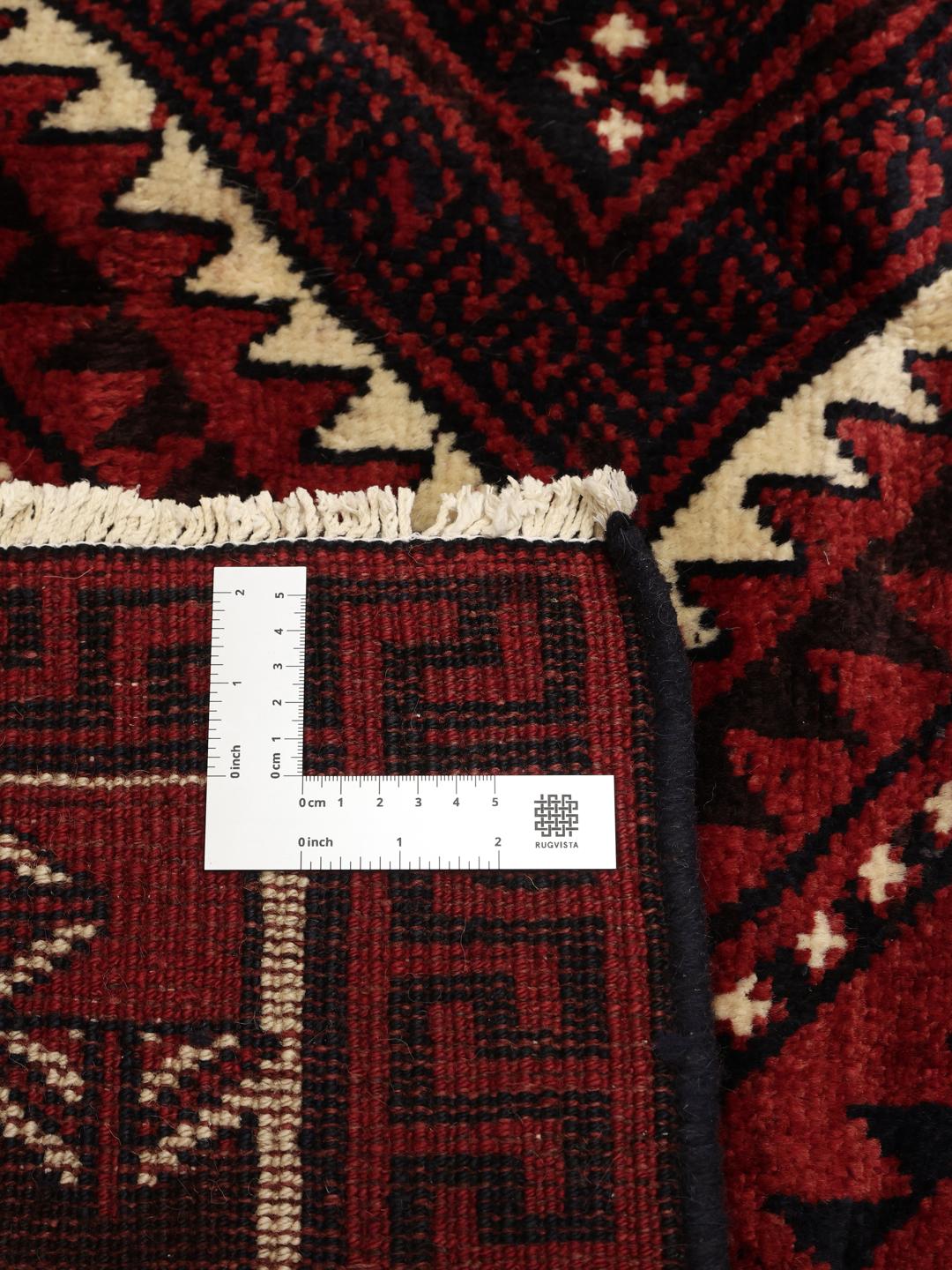 Hand-knotted Lori rug from the Middle East with a deep red and geometric tribal pattern