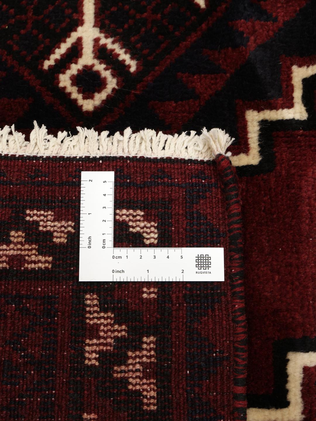A unique hand-knotted Lori rug from the Middle East in dark-red with geometric patterns.