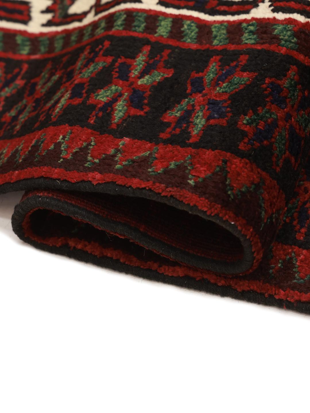 A hand knotted Lori rug from the Middle East with a deep red field and geometric patterns.