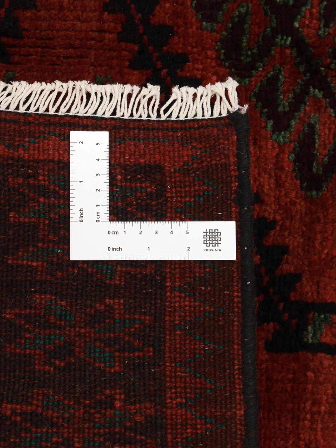 A hand knotted Lori rug from the Middle East with a deep red field and geometric patterns.