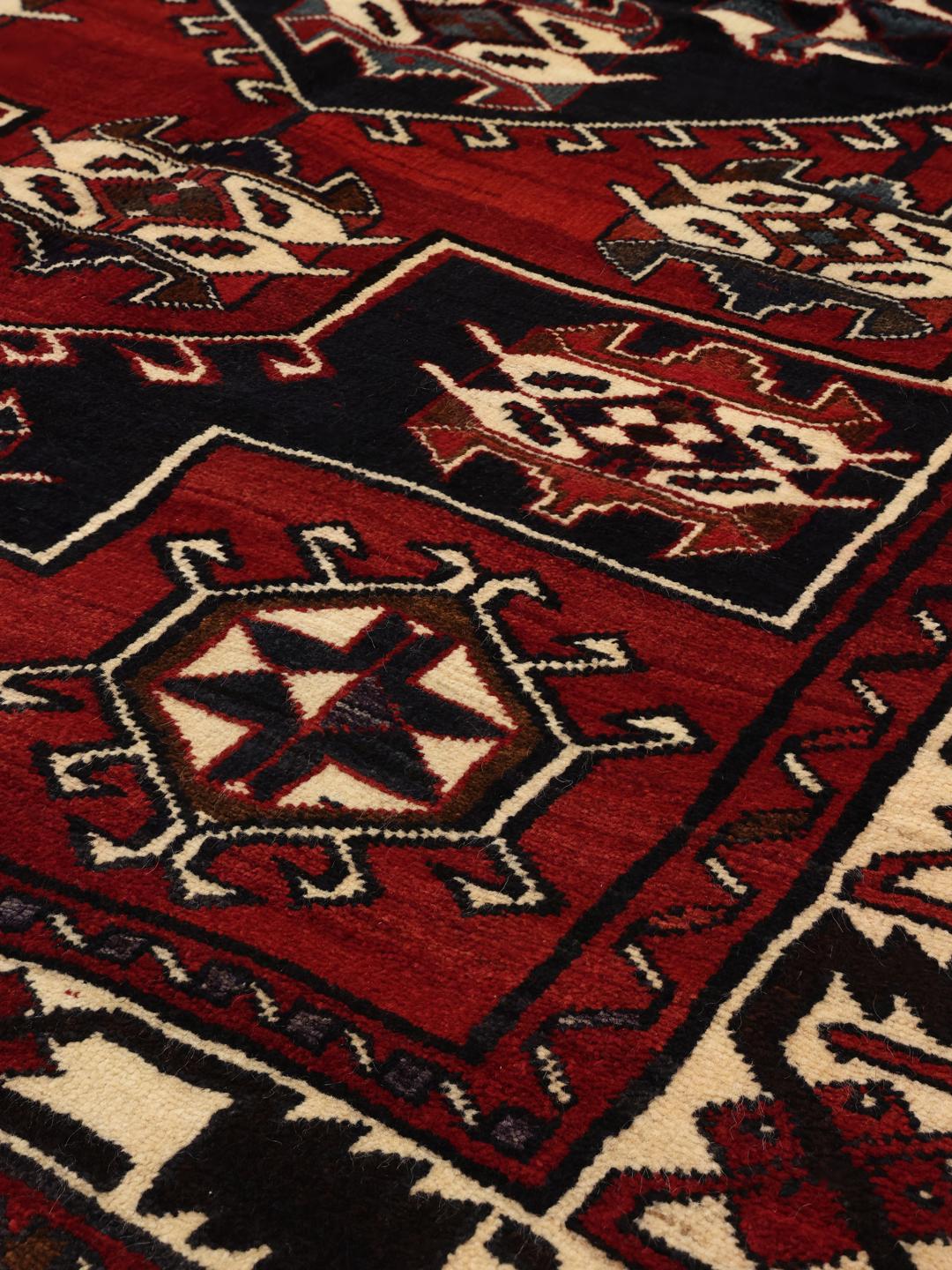 Hand-knotted Lori rug from the Middle East in dark red and black tones