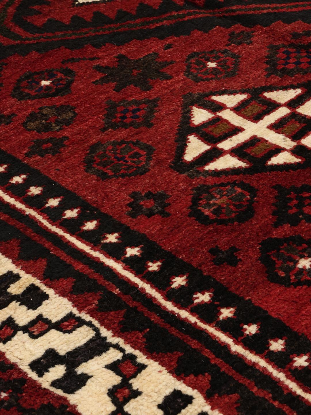 Hand-knotted Lori rug from the Middle East in dark-red and black tones.