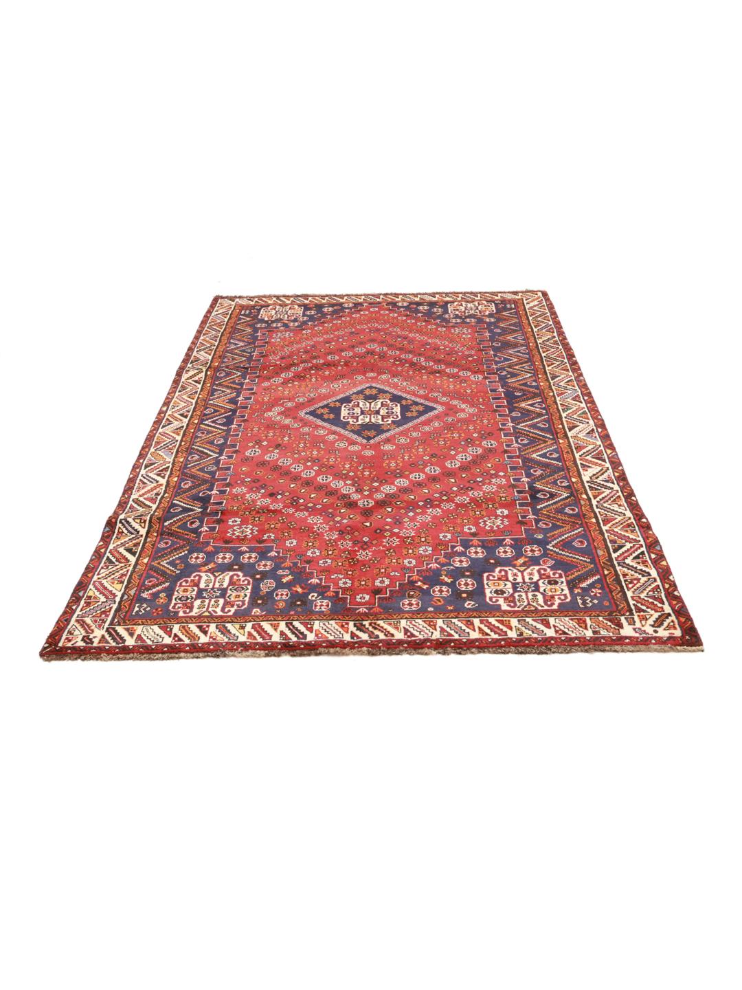 A hand-knotted Ghashghai rug from the Middle East featuring a red and dark-blue colour palette.