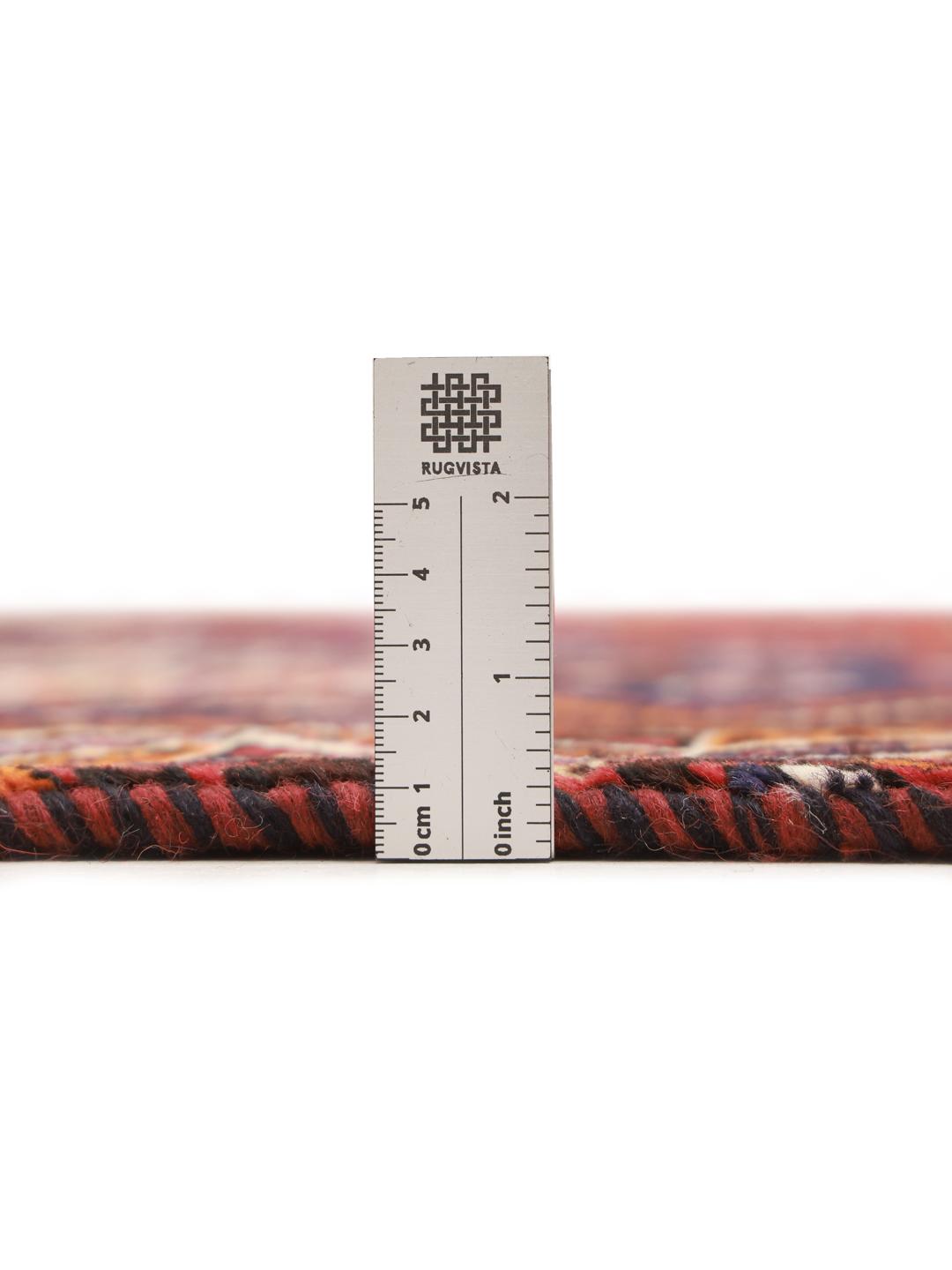 A hand-knotted Ghashghai rug from the Middle East featuring a red and dark-blue colour palette.