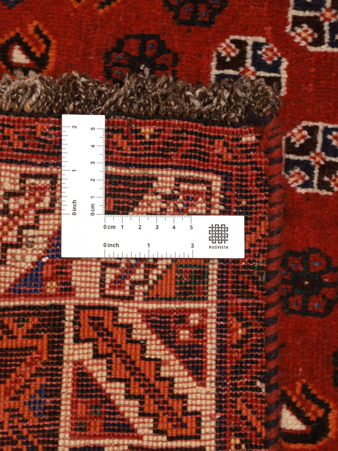 A hand-knotted Ghashghai rug from the Middle East featuring a red and dark-blue colour palette.