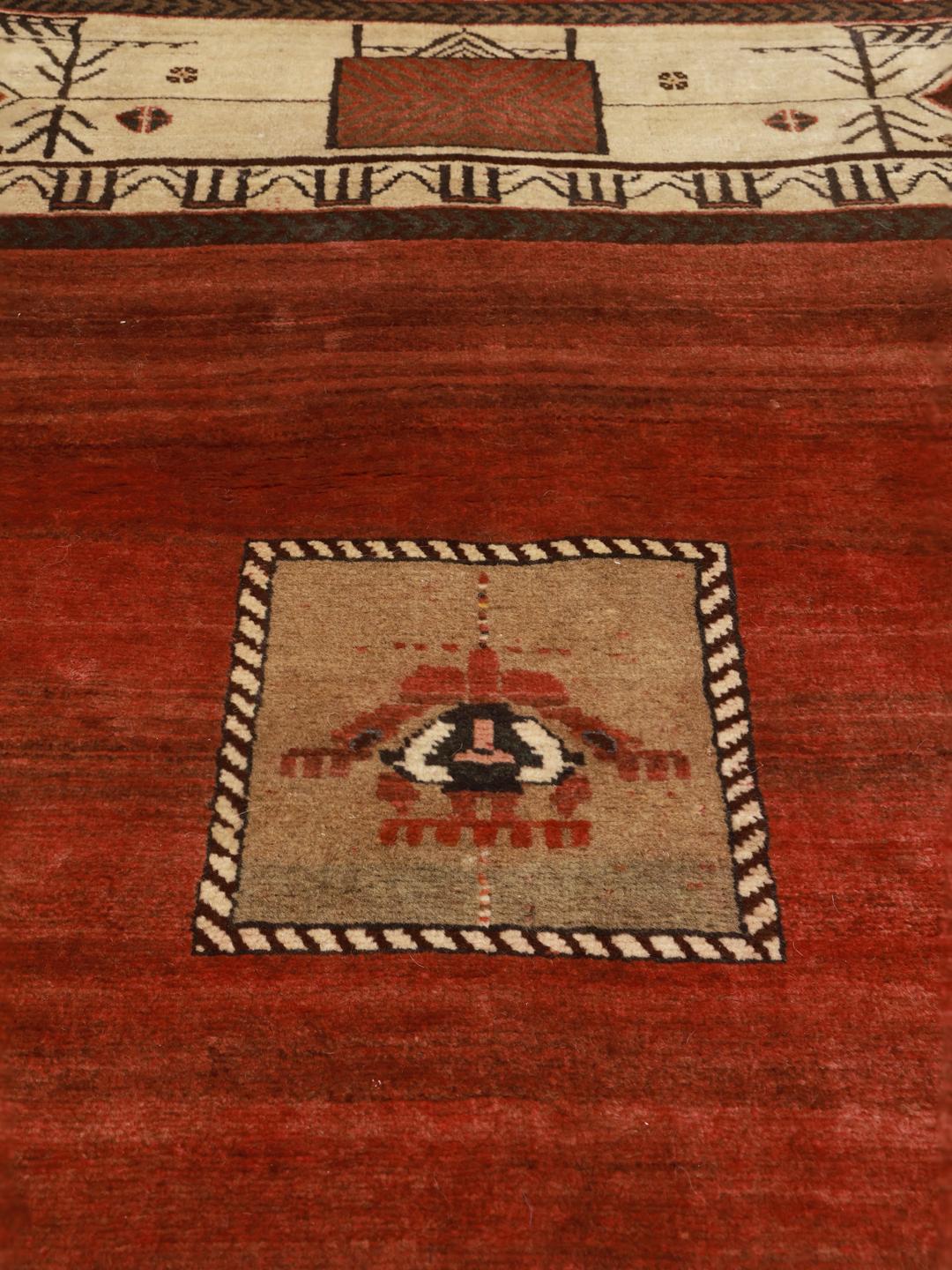 A hand-knotted Shiraz rug from the Middle East featuring a vibrant red field and tribal motifs.