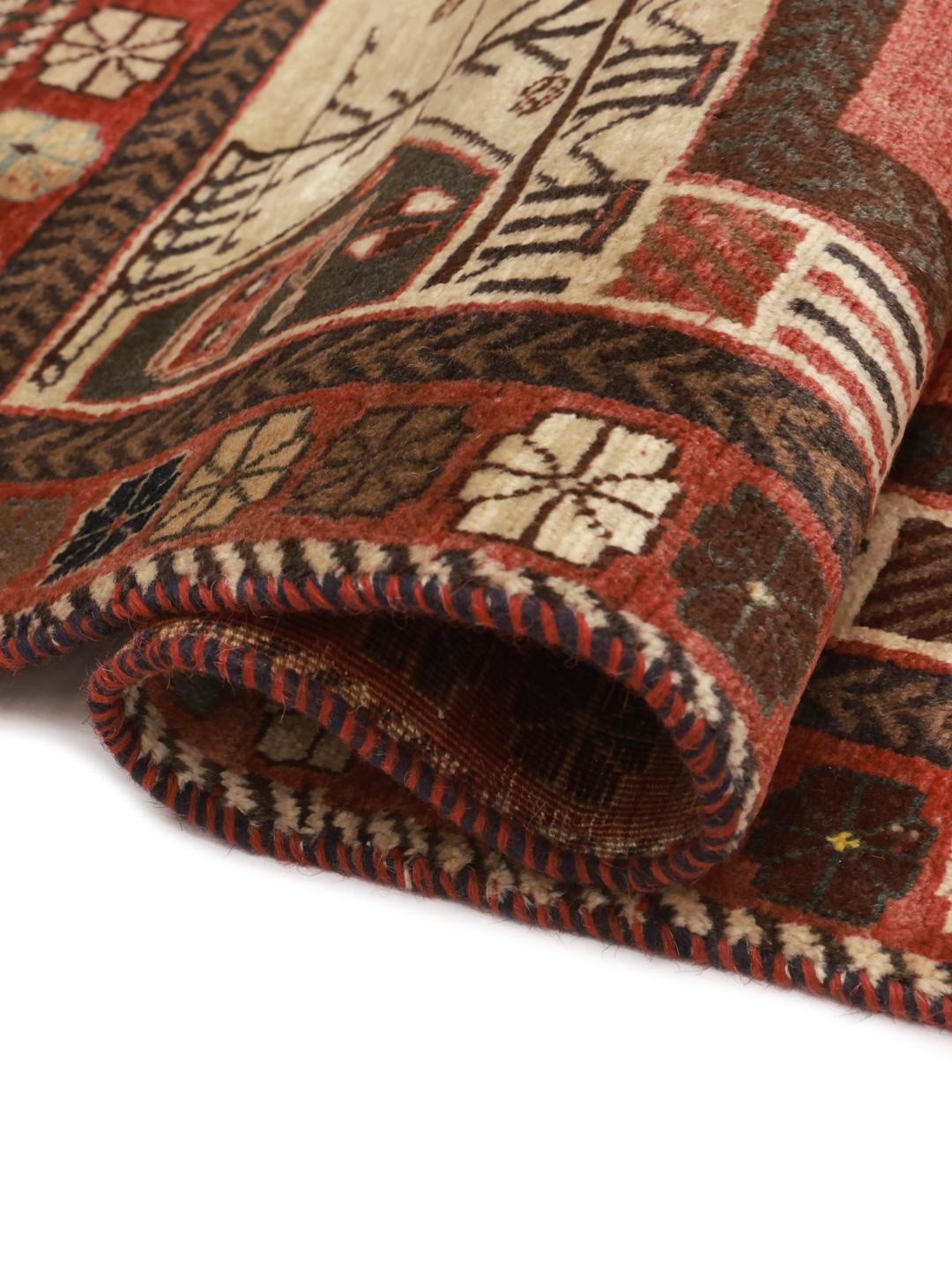 A hand-knotted Shiraz rug from the Middle East featuring a vibrant red field and tribal motifs.