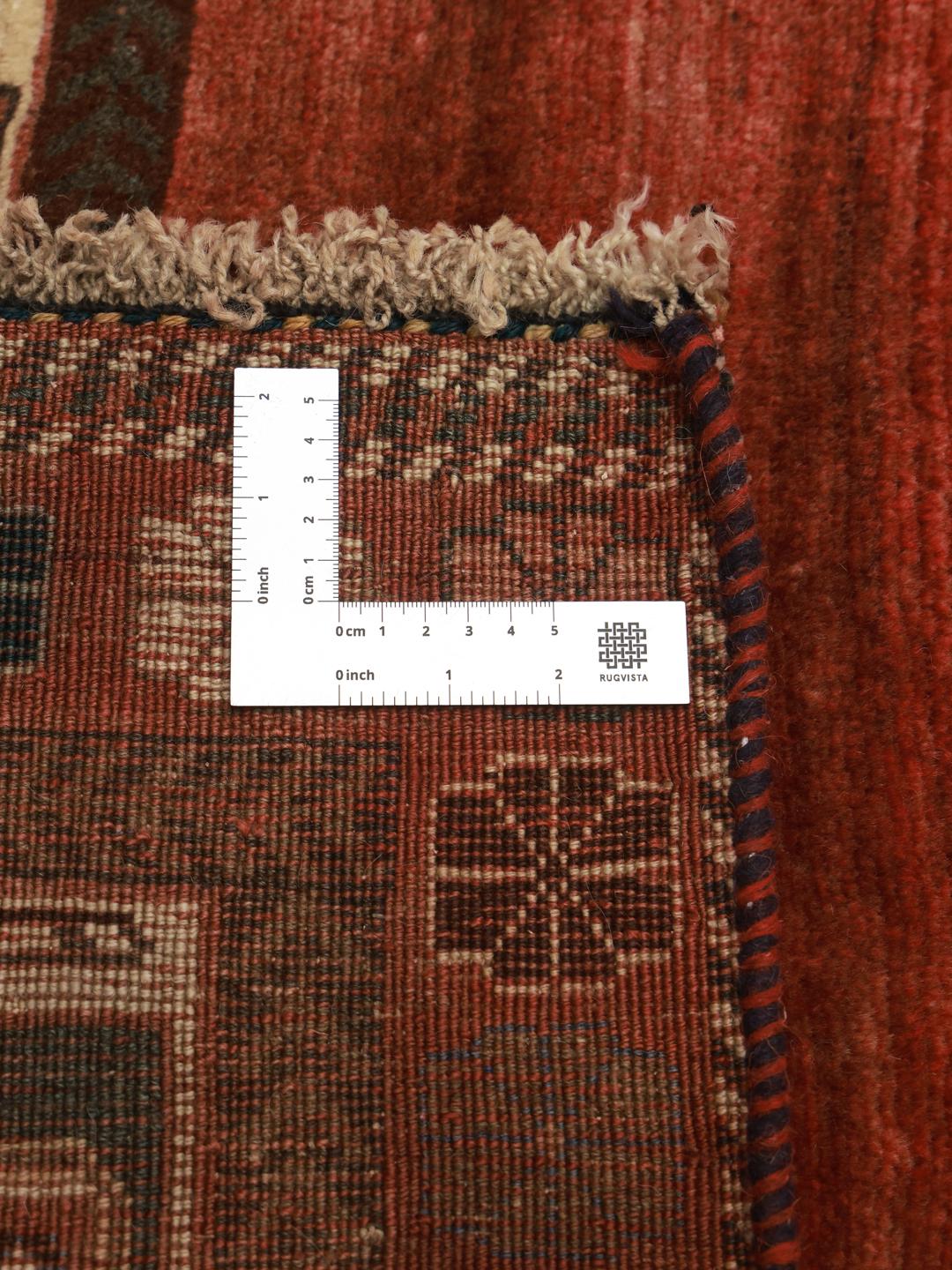 A hand-knotted Shiraz rug from the Middle East featuring a vibrant red field and tribal motifs.