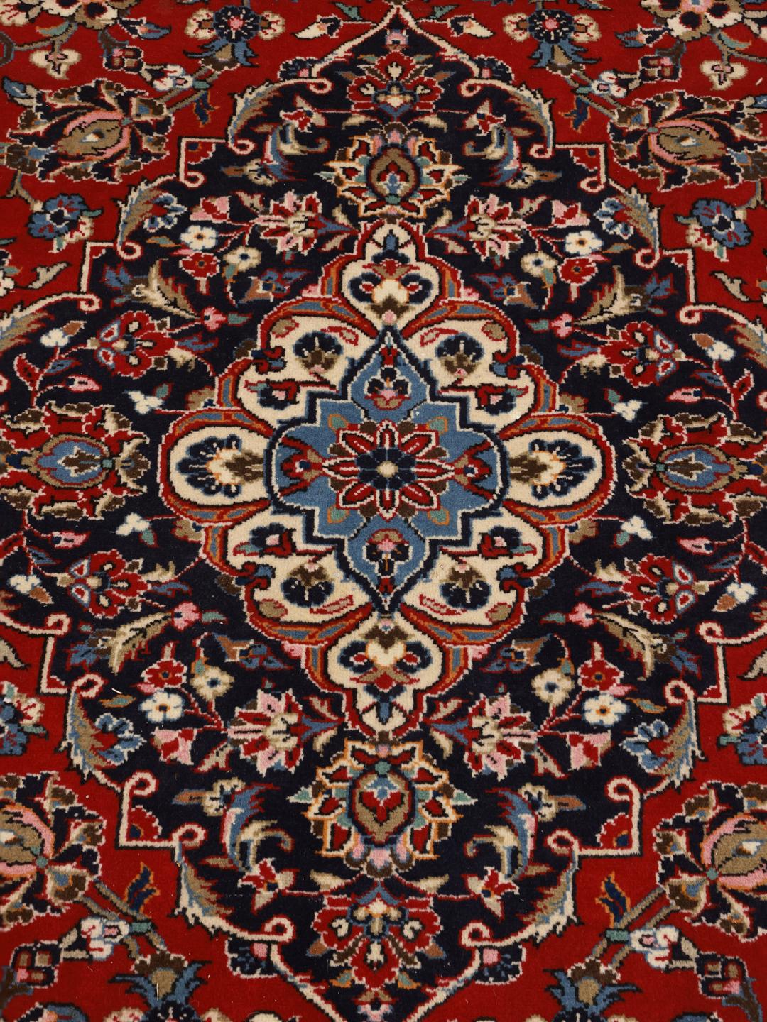 A hand-knotted red Keshan rug from the Middle East with a floral medallion pattern.